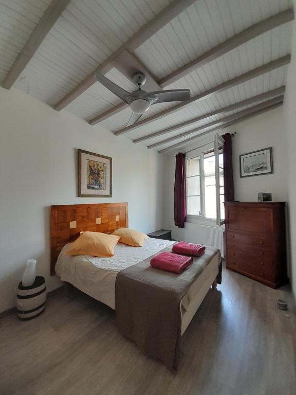 een slaapkamer met een groot bed en een plafond bij La pause sous le pin in Capestang