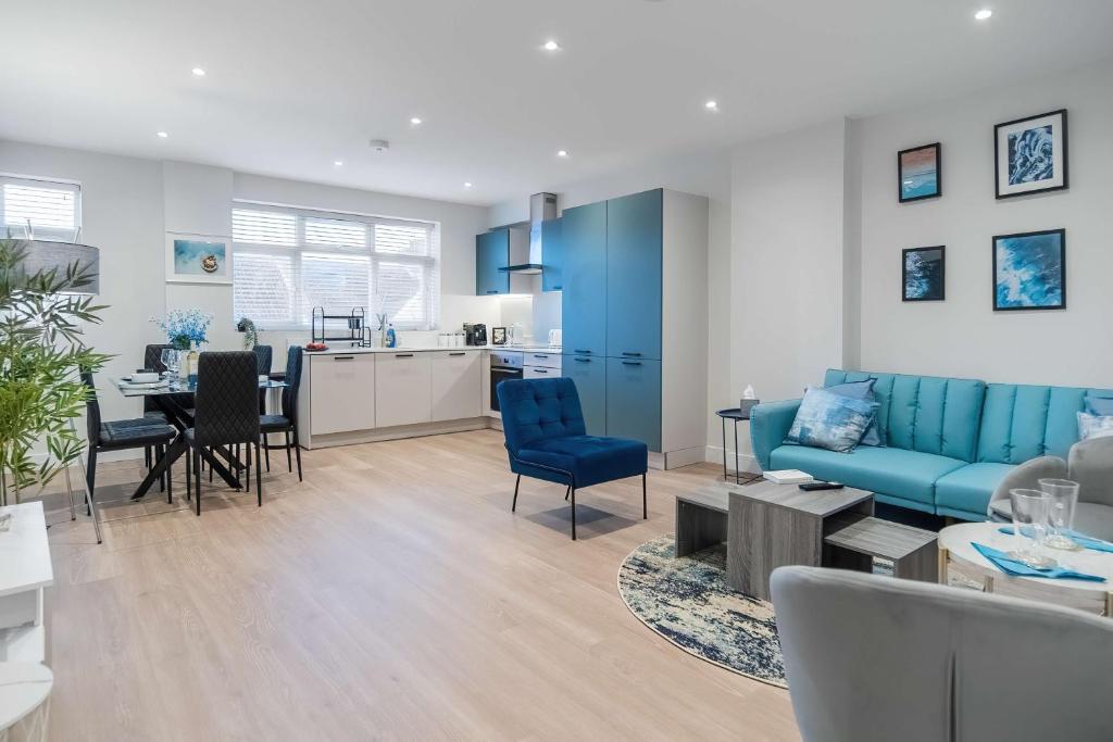 sala de estar con sofá azul y cocina en Livestay-Luxury Apartments in Southend-on-Sea, en Southend-on-Sea