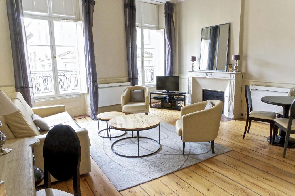 sala de estar con sofá, sillas y chimenea en Saint Rémi - Appartement 1 chambre avec ascenseur en Burdeos