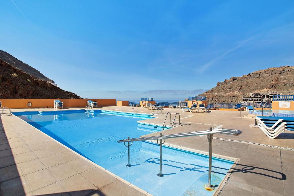 a large swimming pool with a view of the ocean at Paraiso Playa Taurito in Taurito