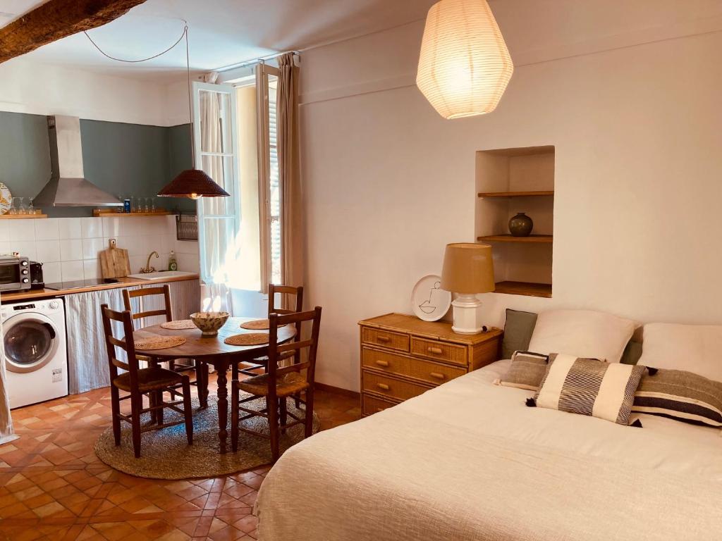 une chambre avec un lit, une table et des chaises dans l'établissement Appartement de charme au coeur du vieux Aix., à Aix-en-Provence