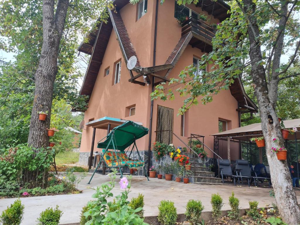 uma casa com um parque infantil em frente em Вила Вайлин em Batak