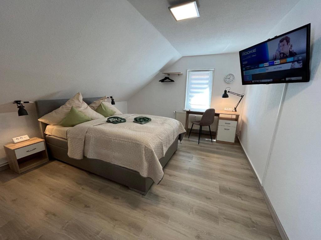 1 dormitorio con 1 cama y TV de pantalla plana en Wohlfuehl-Wohnung-im-Herzen-von-Clausthal, en Clausthal-Zellerfeld