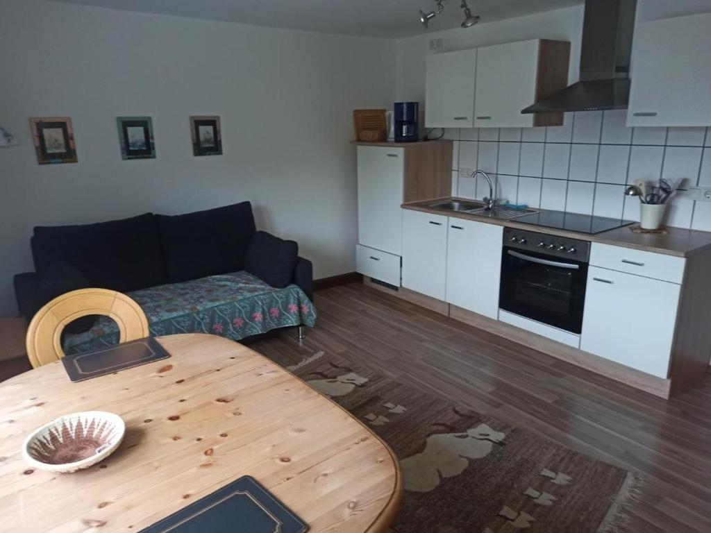 ein Wohnzimmer mit einem Tisch und einer Küche in der Unterkunft NEU Ferienwohnung Biesfeld-Altes Backhaus in Kürten