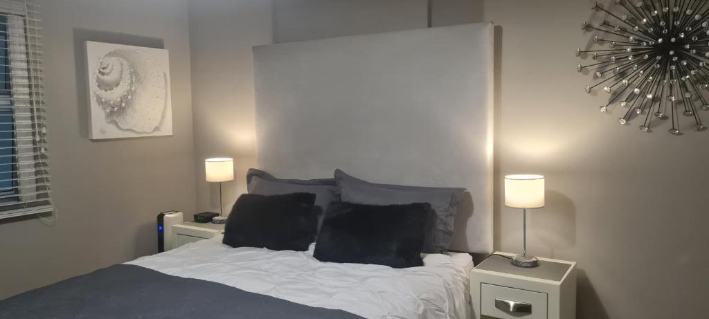 - une chambre avec un lit, deux lampes et un miroir dans l'établissement Beach Club 404, à Mossel Bay