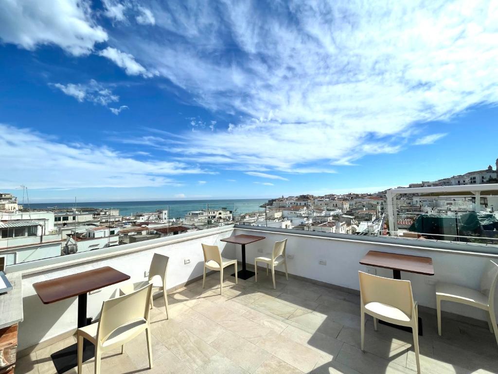 Un balcón con mesas y sillas y vistas al océano. en B&B Teta Vieste, en Vieste