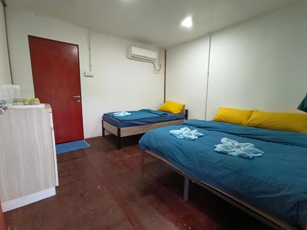 a room with two beds with towels on them at Tiongman Scubadive & Lodge in Tioman Island