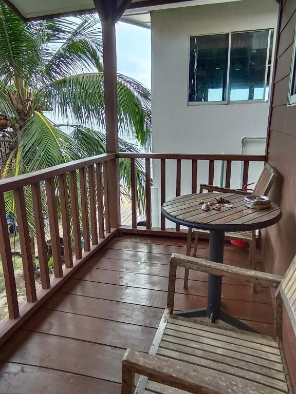 a wooden balcony with a table and chairs on it at Tiongman Scubadive & Lodge in Tioman Island