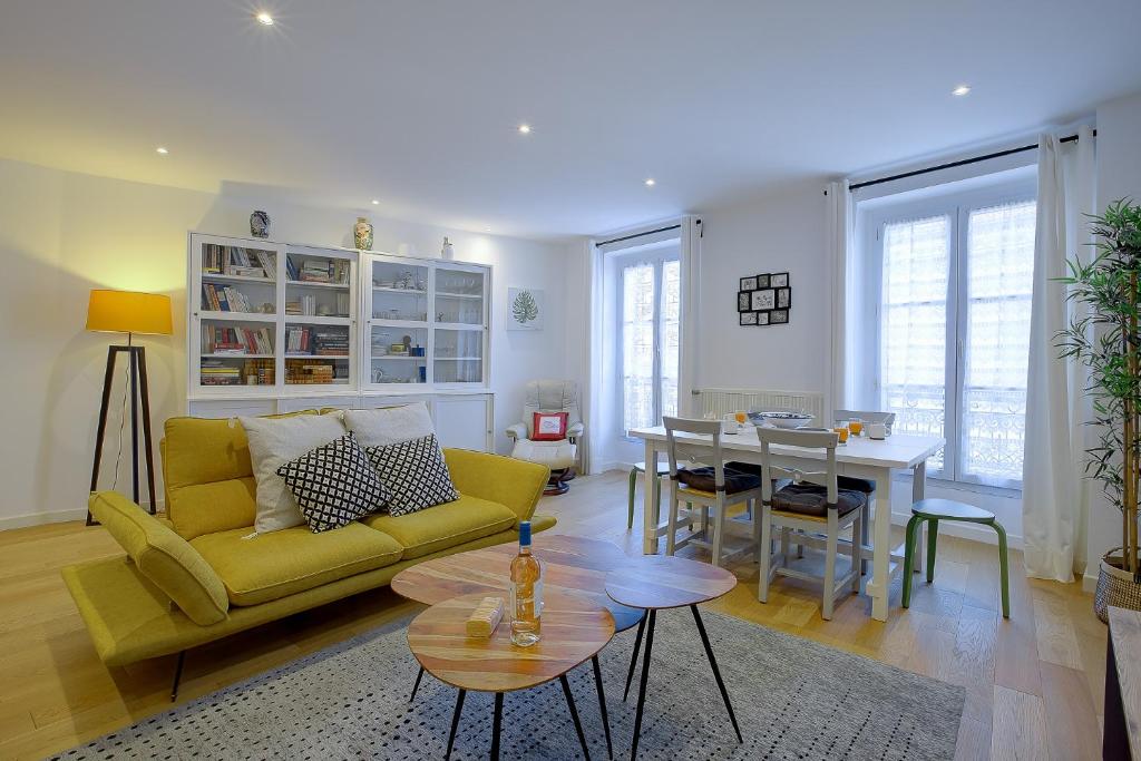 un salon avec un canapé jaune et une table dans l'établissement Maison Bianchi - Saint Philippe, à Nice