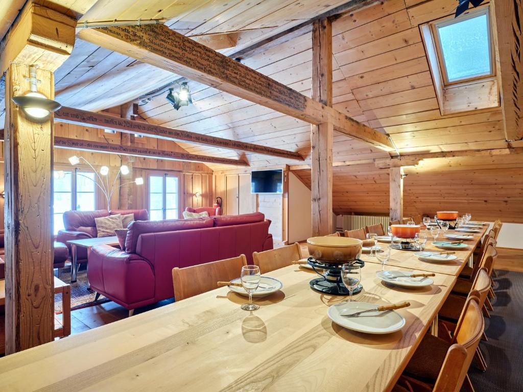 a long wooden table in a room with wooden ceilings at Gästehaus Hof Maiezyt in Habkern