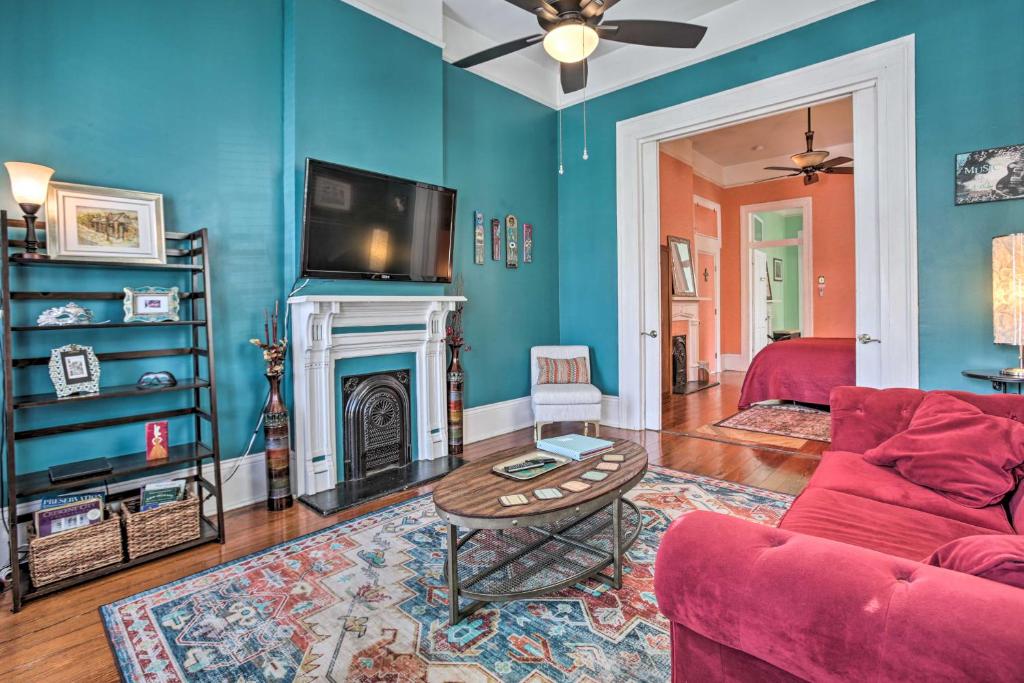 sala de estar con sofá rojo y chimenea en New Orleans Vacation Rental with Private Patio!, en Nueva Orleans