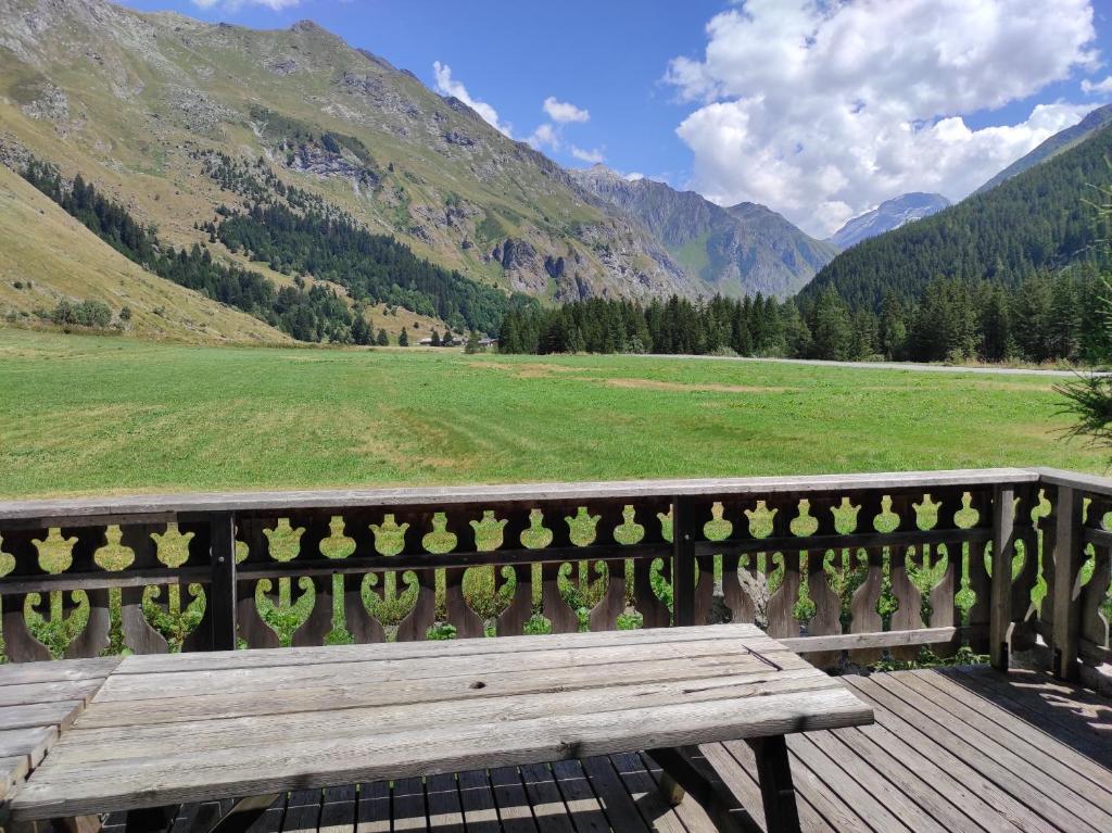 a wooden bench sitting on a deck overlooking a field at Chalet la Grande Motte in Champagny-en-Vanoise