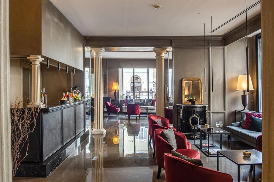 a living room with red chairs and a lobby at Colonna Palace Hotel in Rome