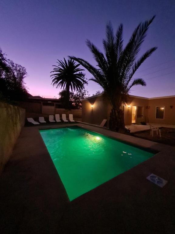 una piscina iluminada por la noche en Cabañas y Loft Parronal, en Vicuña
