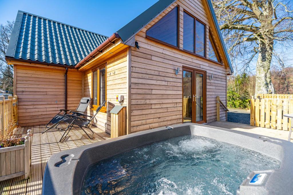 a tiny house with a hot tub in front of it at Roe Deer Lodge with Hot Tub in Cray