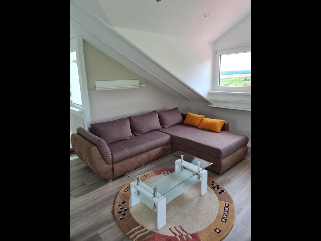 ein Wohnzimmer mit einem Sofa und einem Tisch in der Unterkunft NEU Ferienwohnung Odenwald in Rimhorn