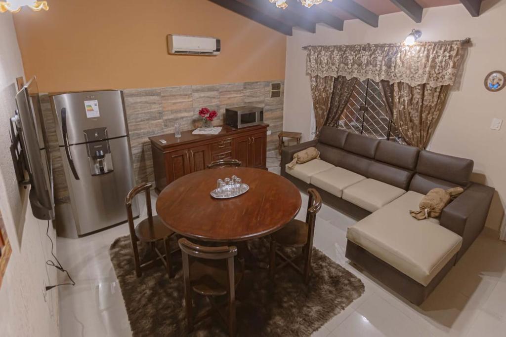 a living room with a couch and a table and a refrigerator at Doña Nelly in Asunción