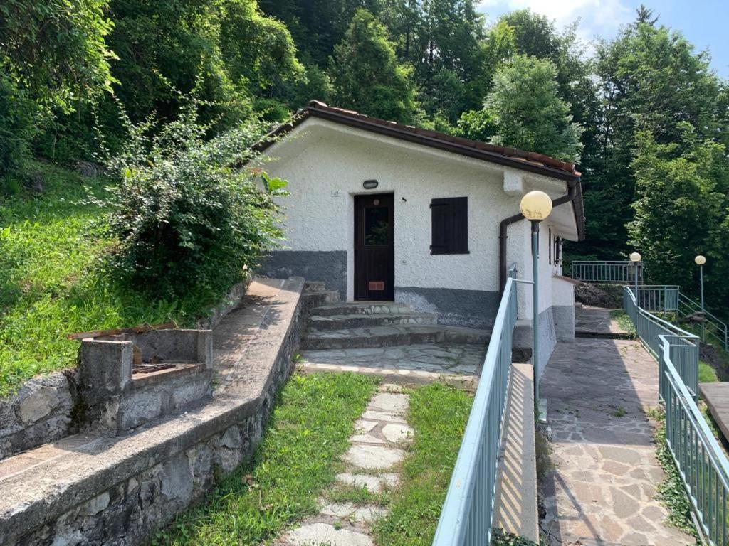 a small white building with a door and a fence at La tana club Suite Oro & Argento in Serina