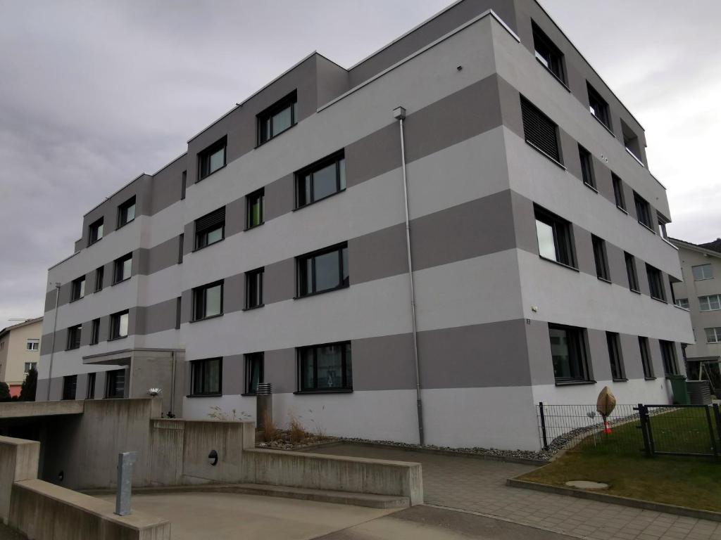 duży biały budynek z czarnymi oknami w obiekcie Ferienwohnung Hirschen w mieście Gossau