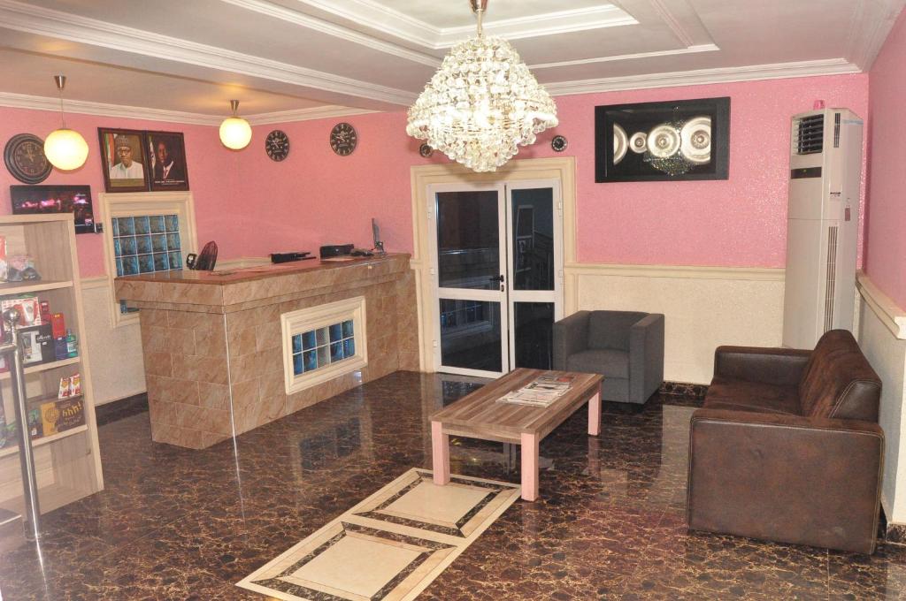 a living room with pink walls and a couch and a table at Ne-yo hotel & rv lodges in Asaba