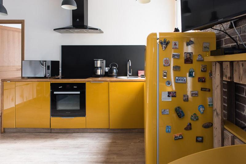 - une cuisine avec un réfrigérateur jaune et des aimants dans l'établissement Charming one-of-a-kind apartment., à Saint-Ouen