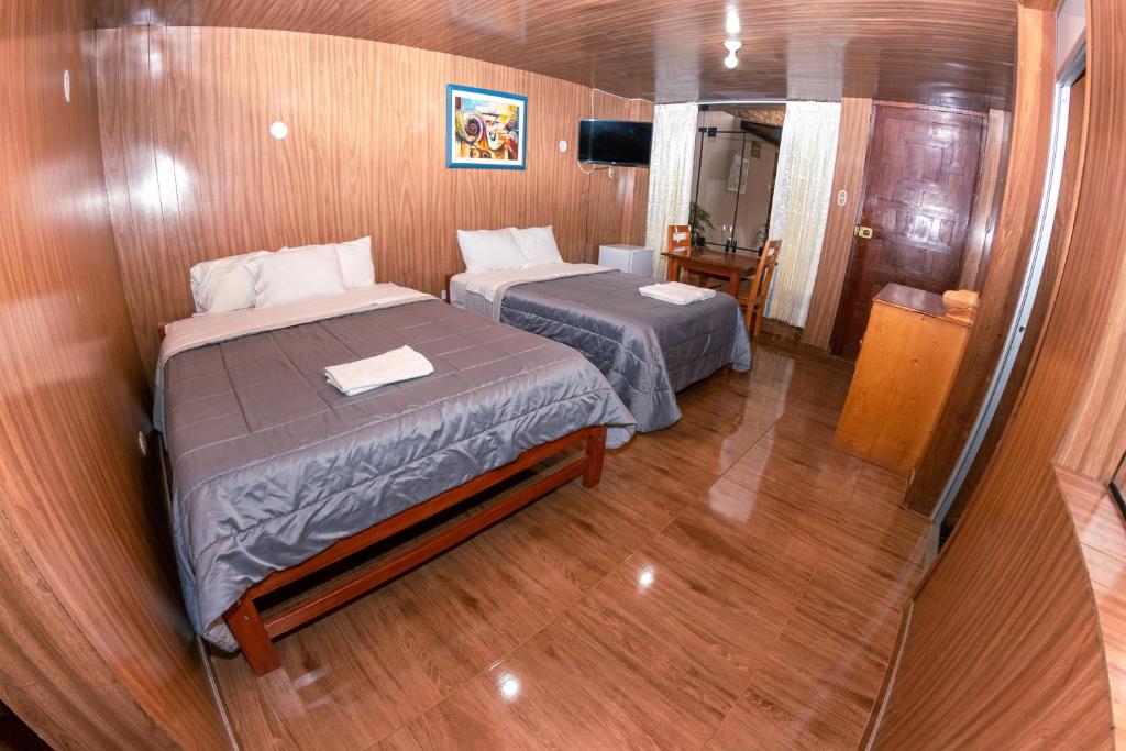 カハマルカにあるHotel La Shacshaの小さな部屋で、ベッド2台、鏡が備わります。