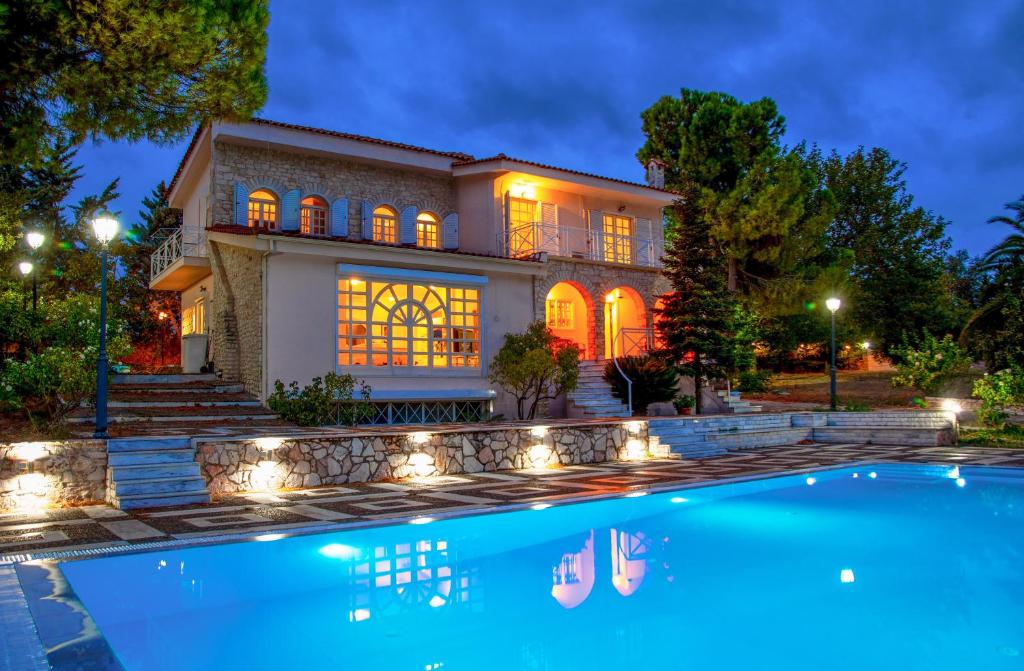 una casa con piscina di fronte a una casa di Eden Garden 3BR villa with Pool by JJ Hospitality a Oropos