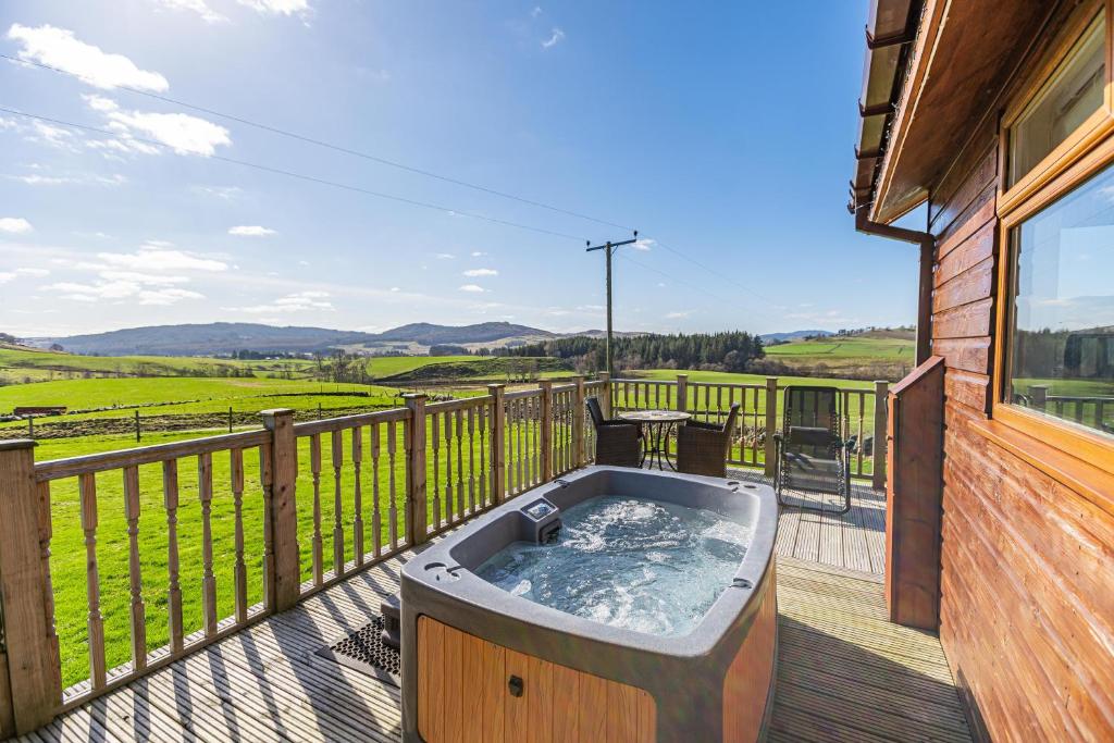 a hot tub on the deck of a house at Pine Marten Lodge with Hot Tub in Cray