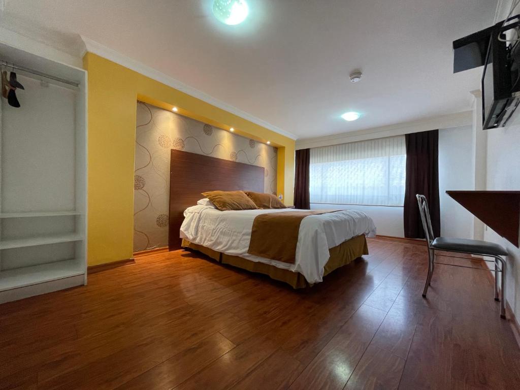 1 dormitorio con 1 cama y TV en Gran Hotel Napoleón, en Ambato