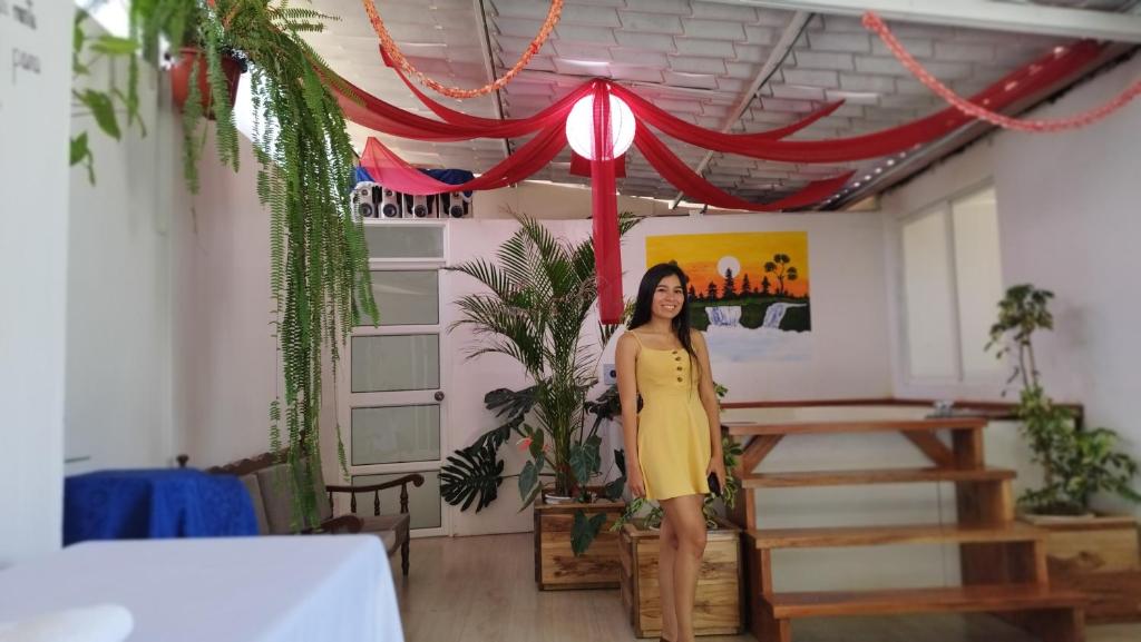 Eine Frau in einem gelben Kleid, die unter einem Regenschirm steht. in der Unterkunft Casa vacacional Isai Hospedaje SPA in Baños