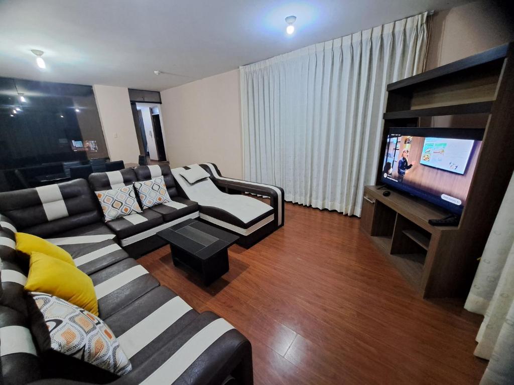 a living room with a couch and a flat screen tv at Departamento amoblado en Arequipa, Cerro Colorado, Urbanización La Merced de Challapampa in Challapampa
