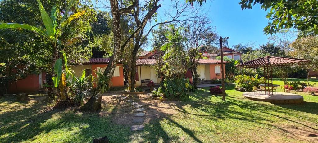 une maison avec un jardin et des arbres dans la cour dans l'établissement Chalé da Paz, à Penedo