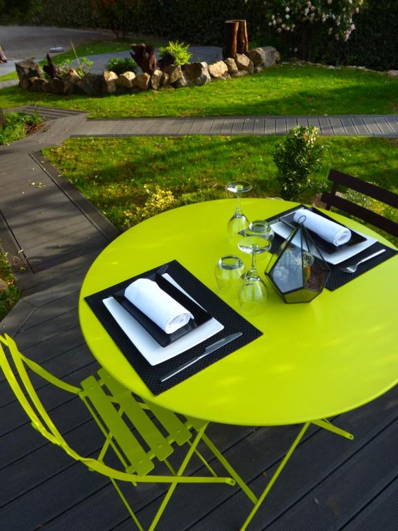 a green dining table with a yellow table at Auberge Les Grillons in Meyras