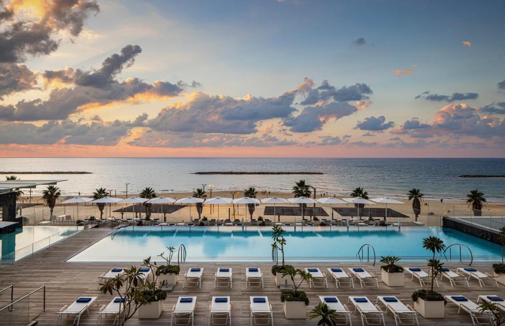 a view of the pool and beach at a resort at The David Kempinski Tel Aviv in Tel Aviv