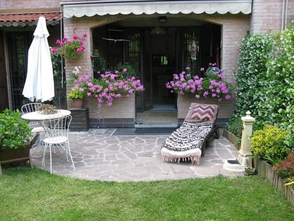 a patio with a bench and a table and flowers at Casa vacanze Monterenzio Bologna in Monterenzio