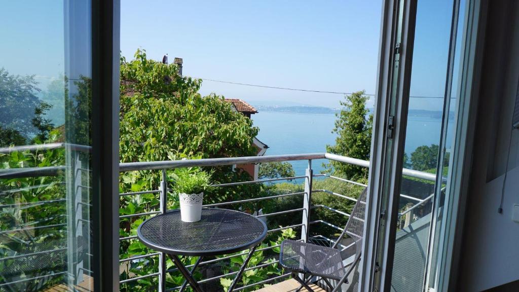 Un balcón con una mesa y vista al agua. en Ferienwohnung Weitsicht, en Meersburg
