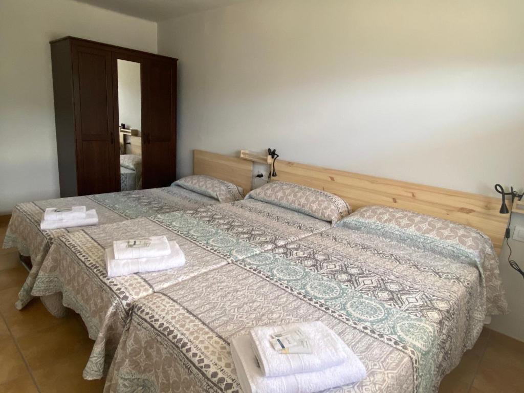 two beds in a room with towels on them at Allotjament Cal Bru in Sant Llorenç de Morunys