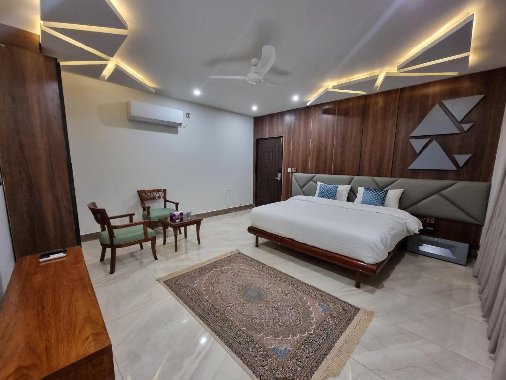sypialnia z łóżkiem, stołem i krzesłem w obiekcie Grand Hotel Quetta w Kwecie