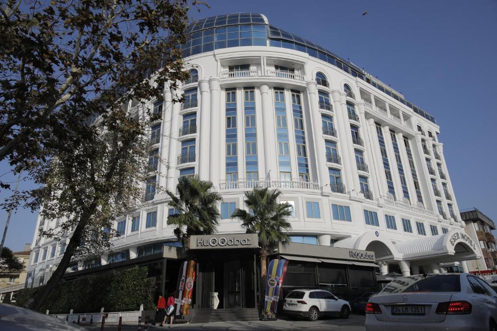 a large white building with cars parked in front of it at Eser Premium Hotel & Spa in Büyükçekmece