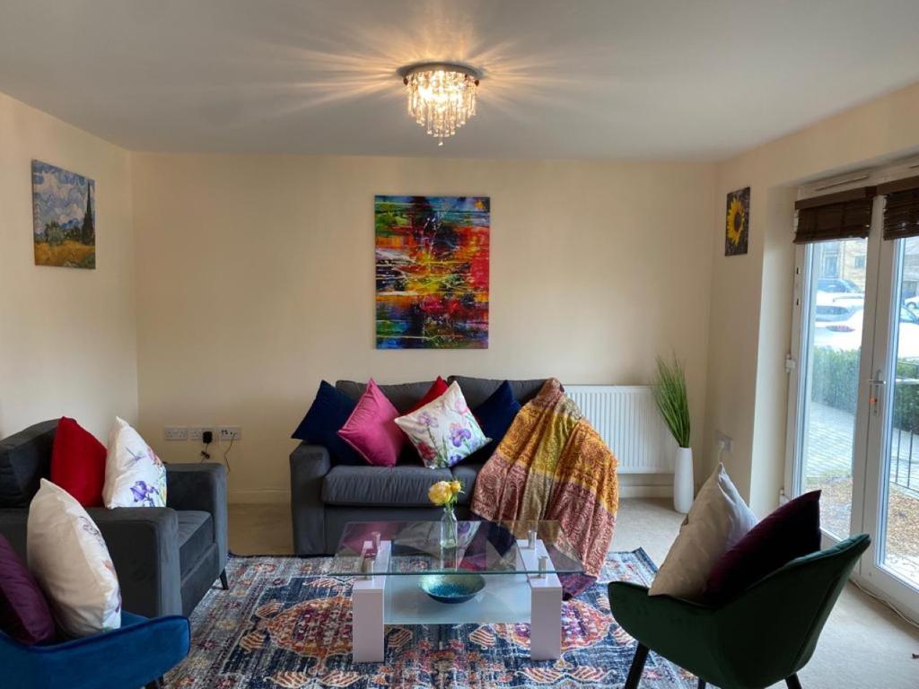 a living room with a couch and a glass table at Exquisite Modern Homely 2 Bed Apartment with On-street Parking, Super Fast WIFI & 5 mins drive to Science & Business Parks in Cambridge