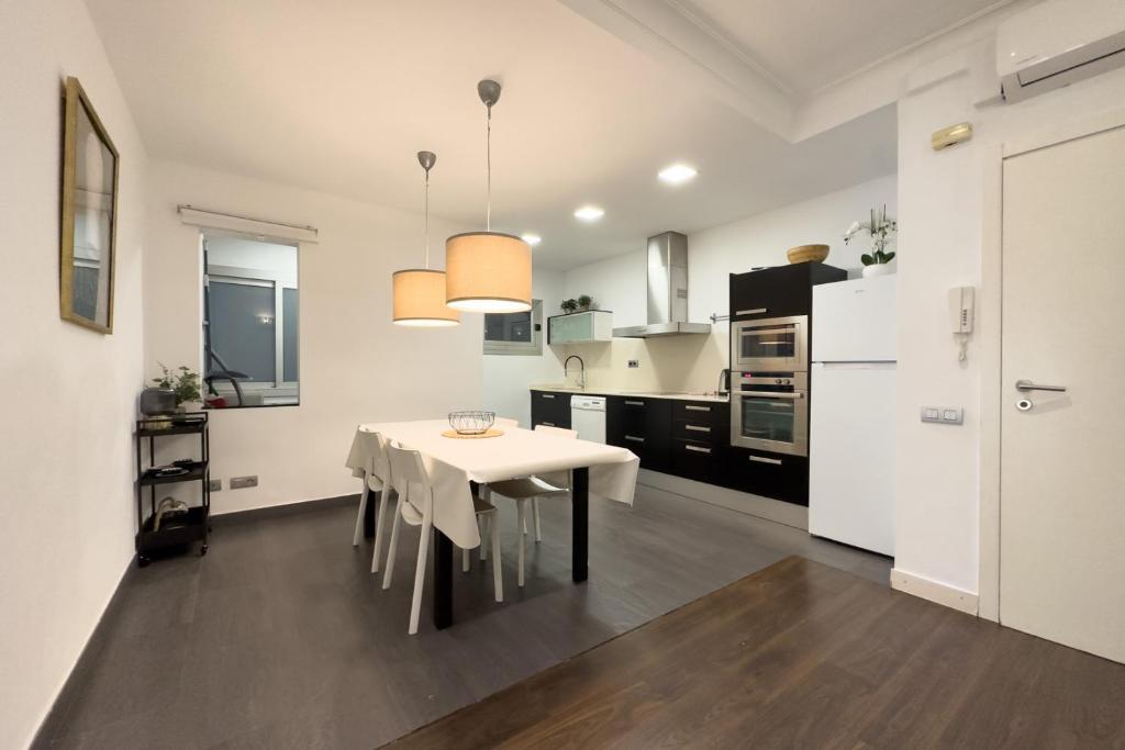 a kitchen with a white table and a white refrigerator at Key Sagrada Família & Park Guell Apartment in Barcelona