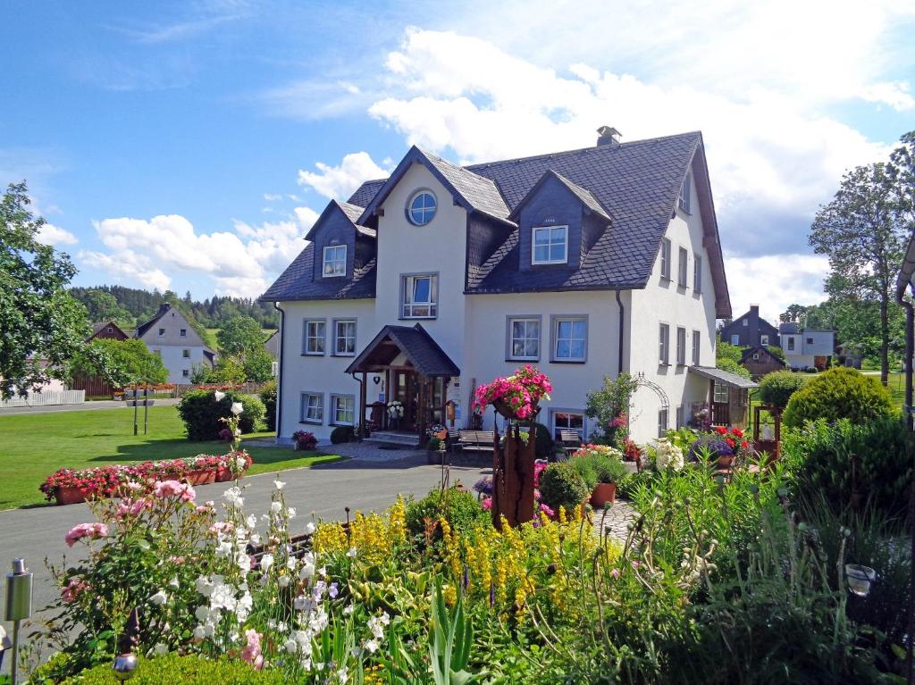 ein großes weißes Haus mit Blumen davor in der Unterkunft Gästehaus Frankenwaldhof in Bad Steben