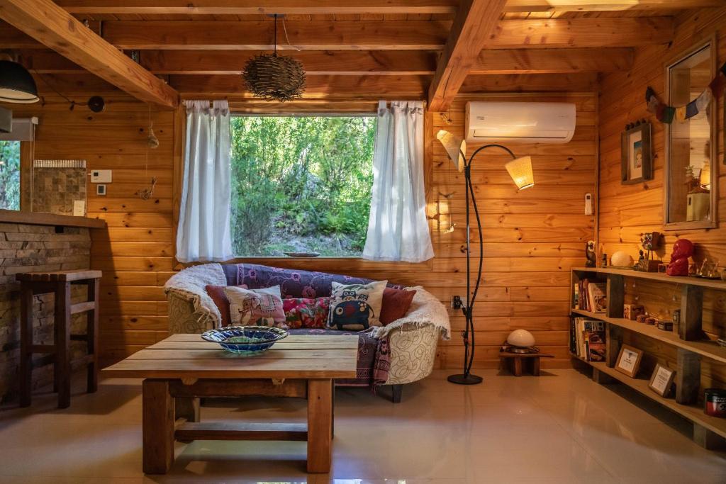 sala de estar con sofá y mesa en BOG Budas del Bosque en Villa La Angostura