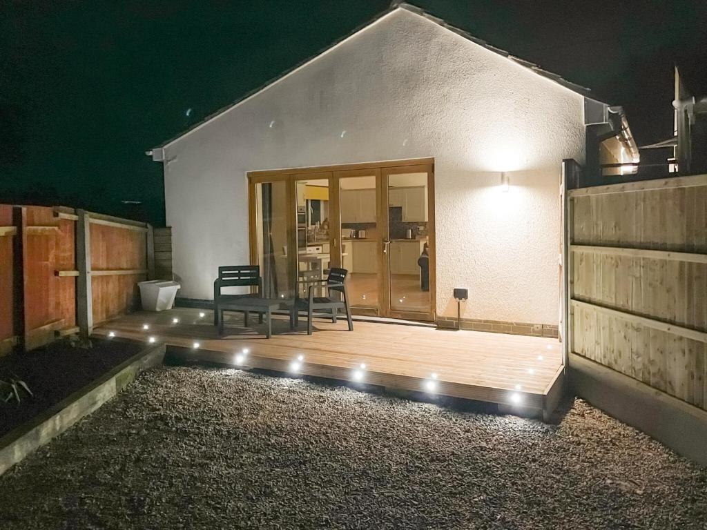 a house with a deck with two chairs and lights at Woodside Retreat, Number 37 in Worthington