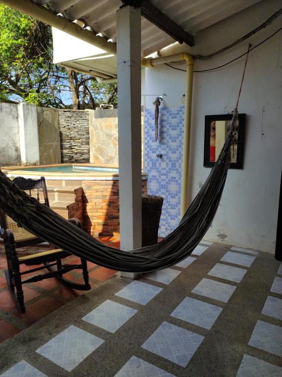 eine Hängematte, die von einer Veranda mit Pool hängt in der Unterkunft Casa Bondigua in Santa Marta