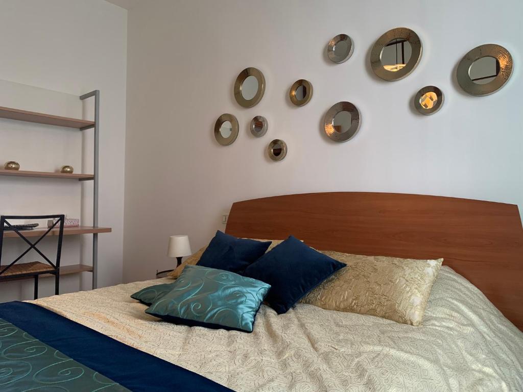 a bedroom with a bed with blue pillows and clocks on the wall at Appartement GIUDECCA in Venice