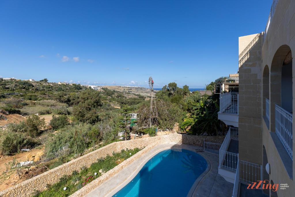 arial view of a building with a swimming pool at The Grove Valley Views Apartment w/ Communal Pool in Xagħra