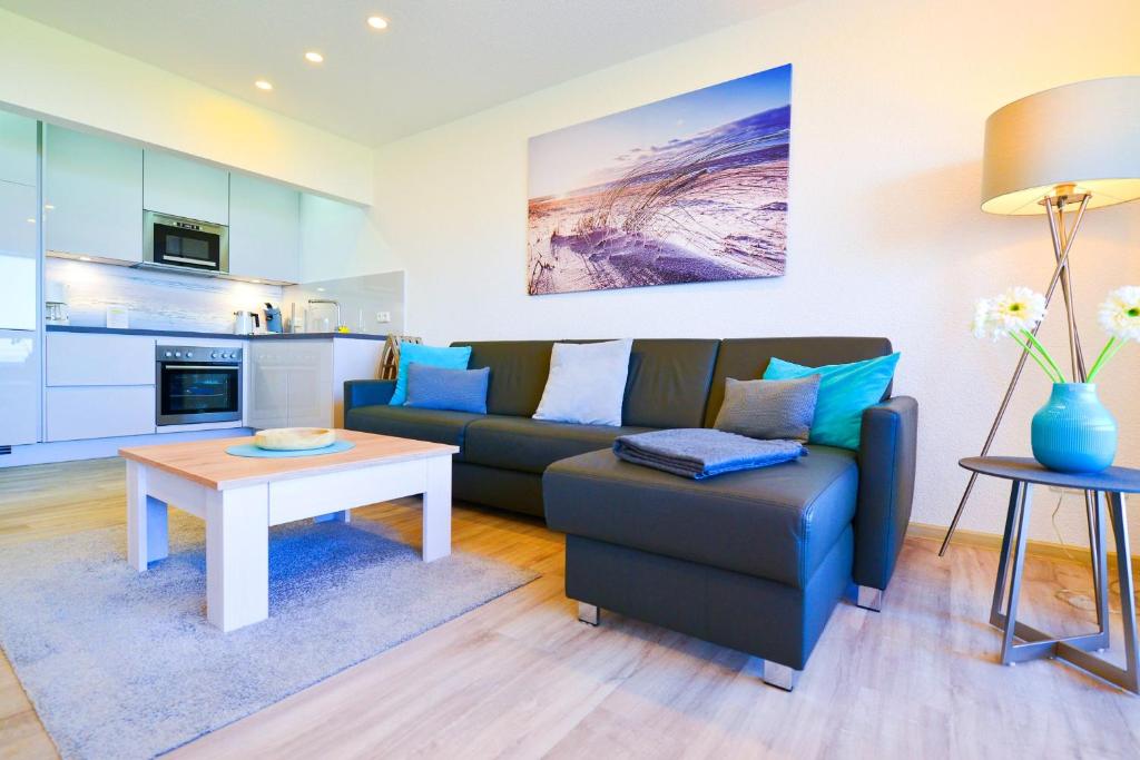 ein Wohnzimmer mit einem Sofa und einem Tisch in der Unterkunft Am Sahlenburger Strand AS01 in Cuxhaven