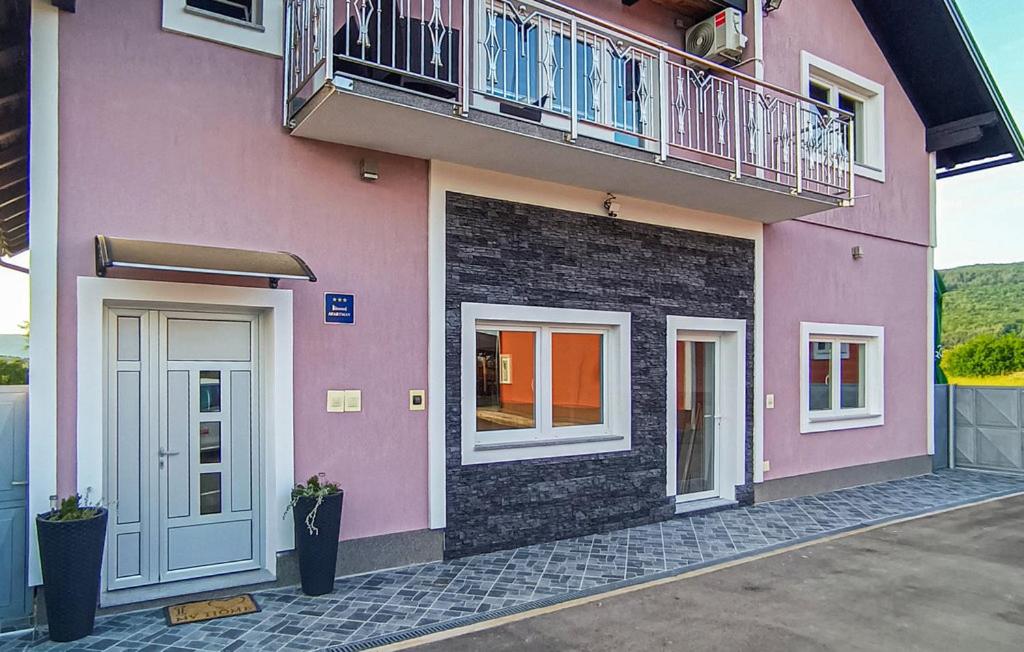 a pink building with a balcony on top of it at Apartments Sweet Home in Otočac