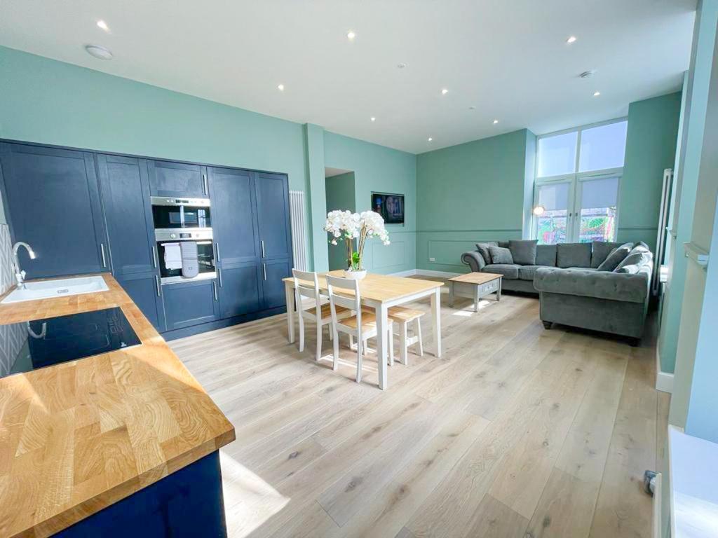 Il comprend une cuisine et un salon avec une table et un canapé. dans l'établissement Beautiful 2BR, Private Entry in Vibrant Leith, à Édimbourg